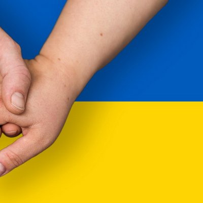 Ukrainische Flagge, davor drei ineinandergreifende Hände